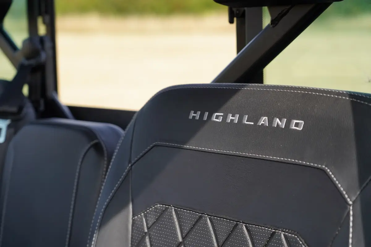 Close-up of a black UFORCE U10 PRO HIGHLAND car seat with "HIGHLAND" embroidered on the headrest, featuring detailed stitching and an eye-catching geometric pattern.