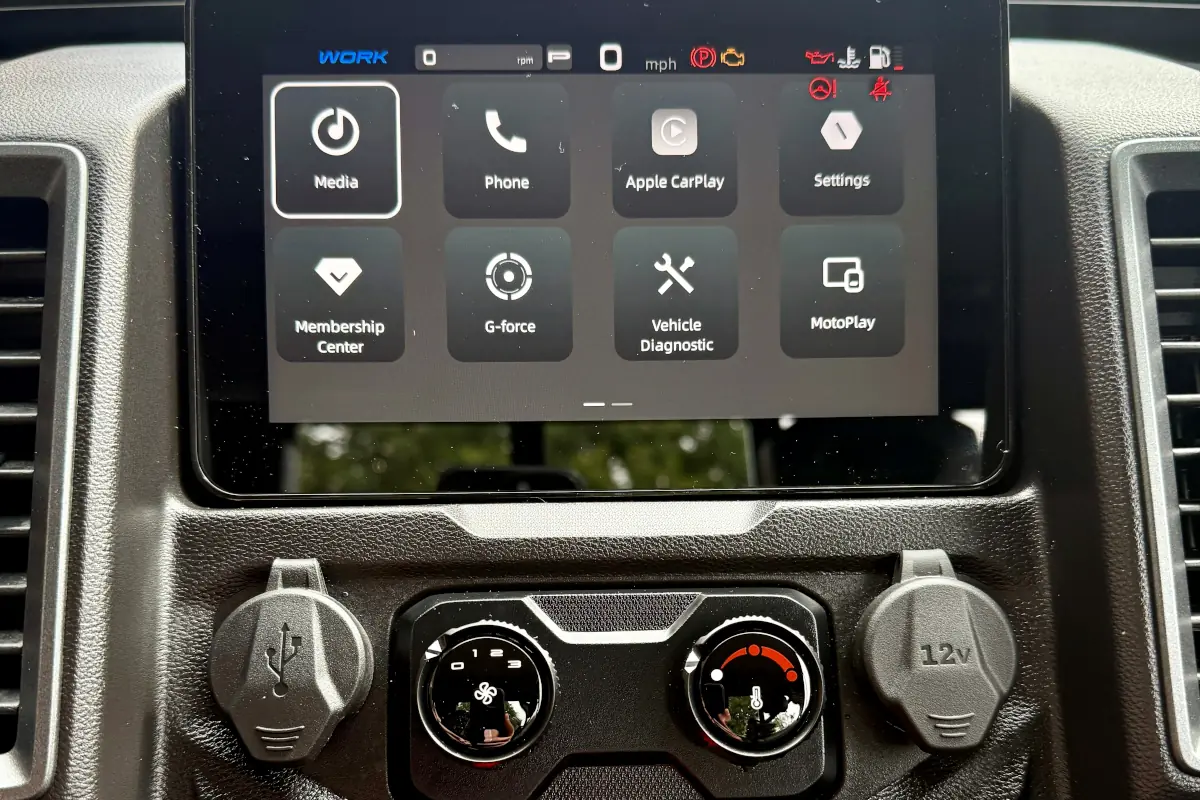Close-up of the UFORCE U10 PRO HIGHLAND’s touchscreen dashboard display showing various app icons and controls, with air conditioning dials and a 12V power outlet below.
